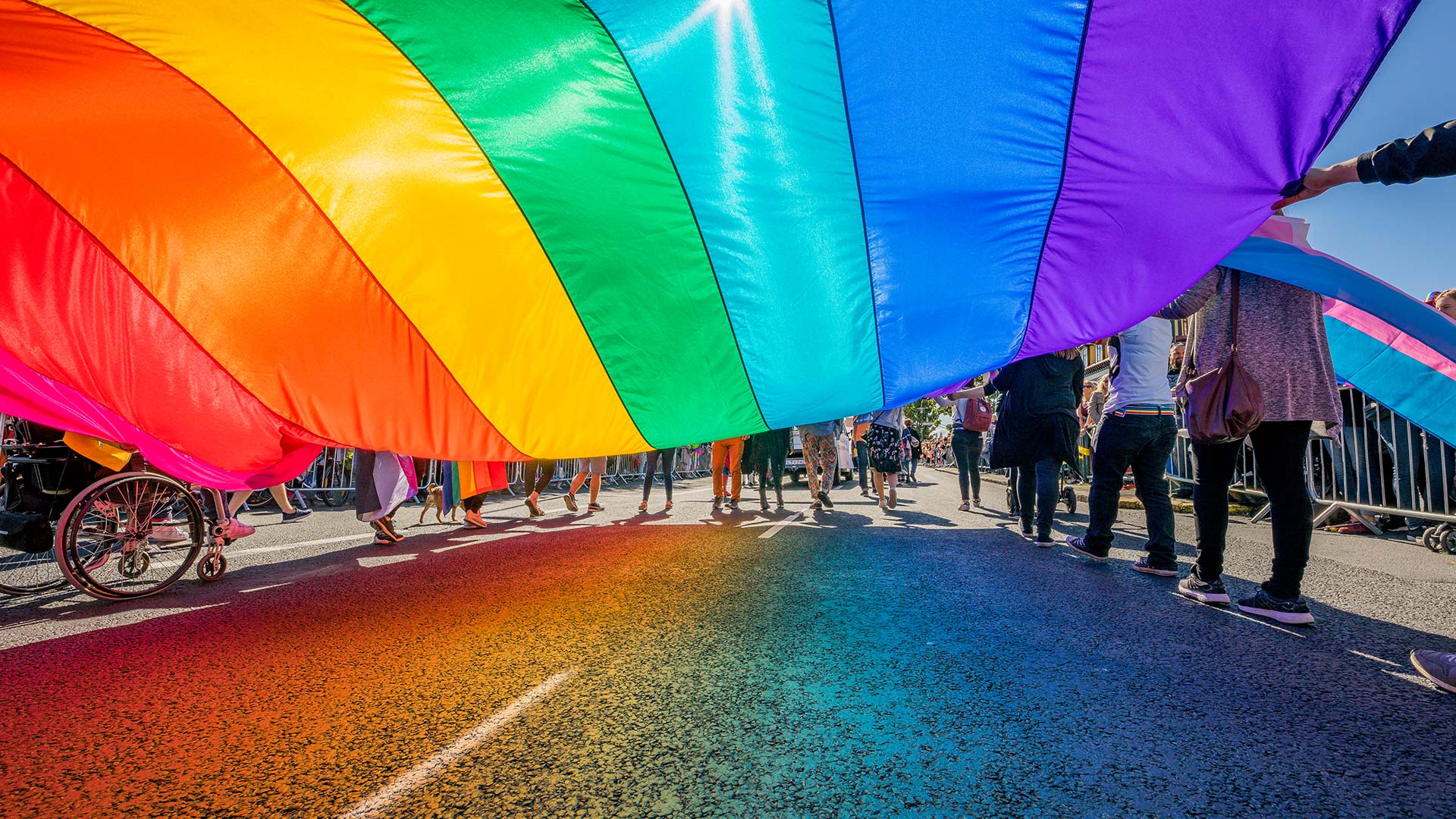 rainbow-flag-being-carried-along-street-parade-01.jpg