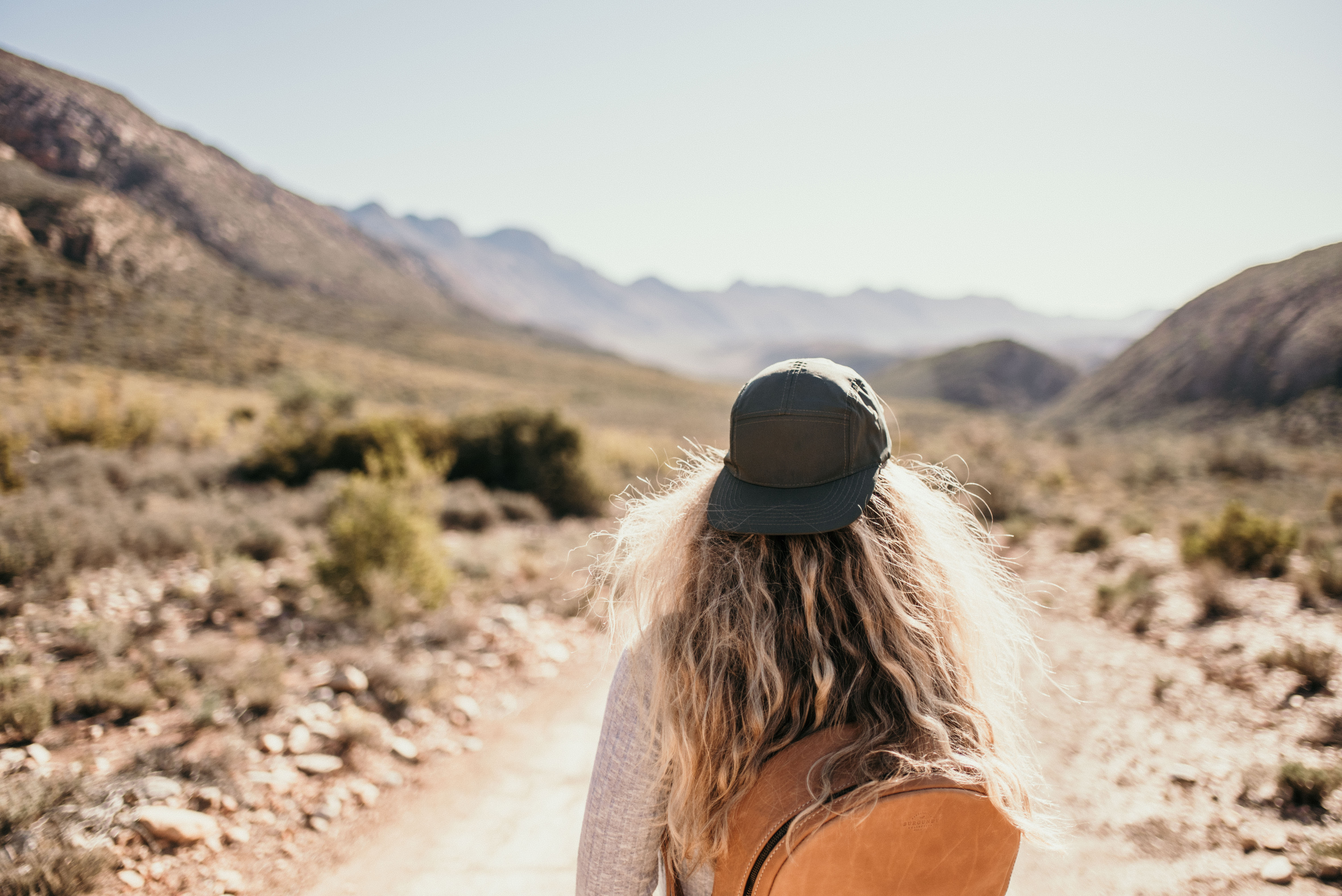 woman-walking-in-karoo-desert-with-cap-and-blond-hair-AdobeStock_519652673.jpeg